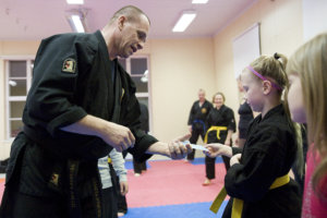 Katariina Salminen (oikealla), Kristiina Westerberg ja Tarja Vaittinen-Rönni treenaavat naisten itsepuolustuskurssilla, Minna Liljedahl combat hapkidossa.