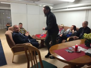 Jutustelun lomassa juotiin glögiä ja syötiin joulutorttuja sekä piparkakkuja. Kuvan keskellä Tuomo Jussila häärii isännän roolissa. 