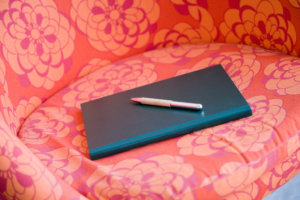 Muistikirja ja kynä tuolilla