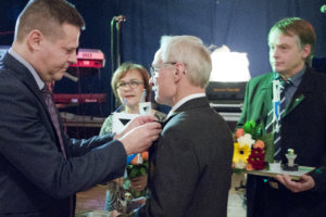 Pirkanmaan Yrittäjien varapuheenjohtaja Jari Haapaniemi kiinnittää pinssiä Luopioisten Vuoden Yrittäjä -palkinnon saaneelle Aaro Turuselle.