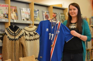 Heidi Koivula esittelee Islannin jalkapallomaajoukkueen fanipaitaa.
